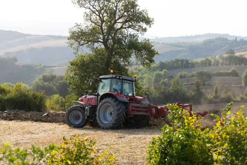 A tractor is driving down a dirt road